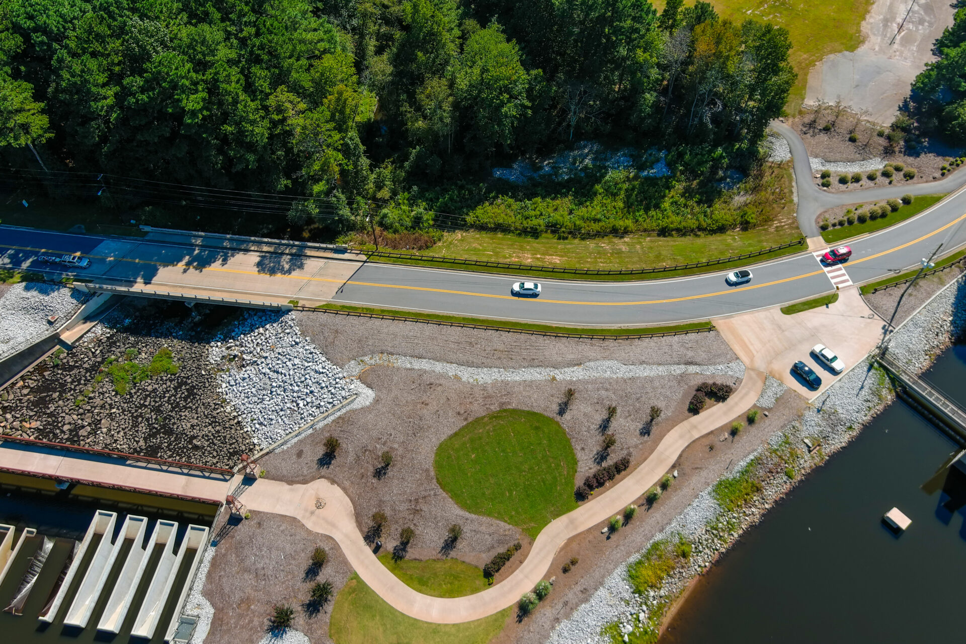 a stunning aerial shot of the lake surrounded by lush green trees and the street along the lake with cars at Lake Peachtree in Peachtree City Georgia USA