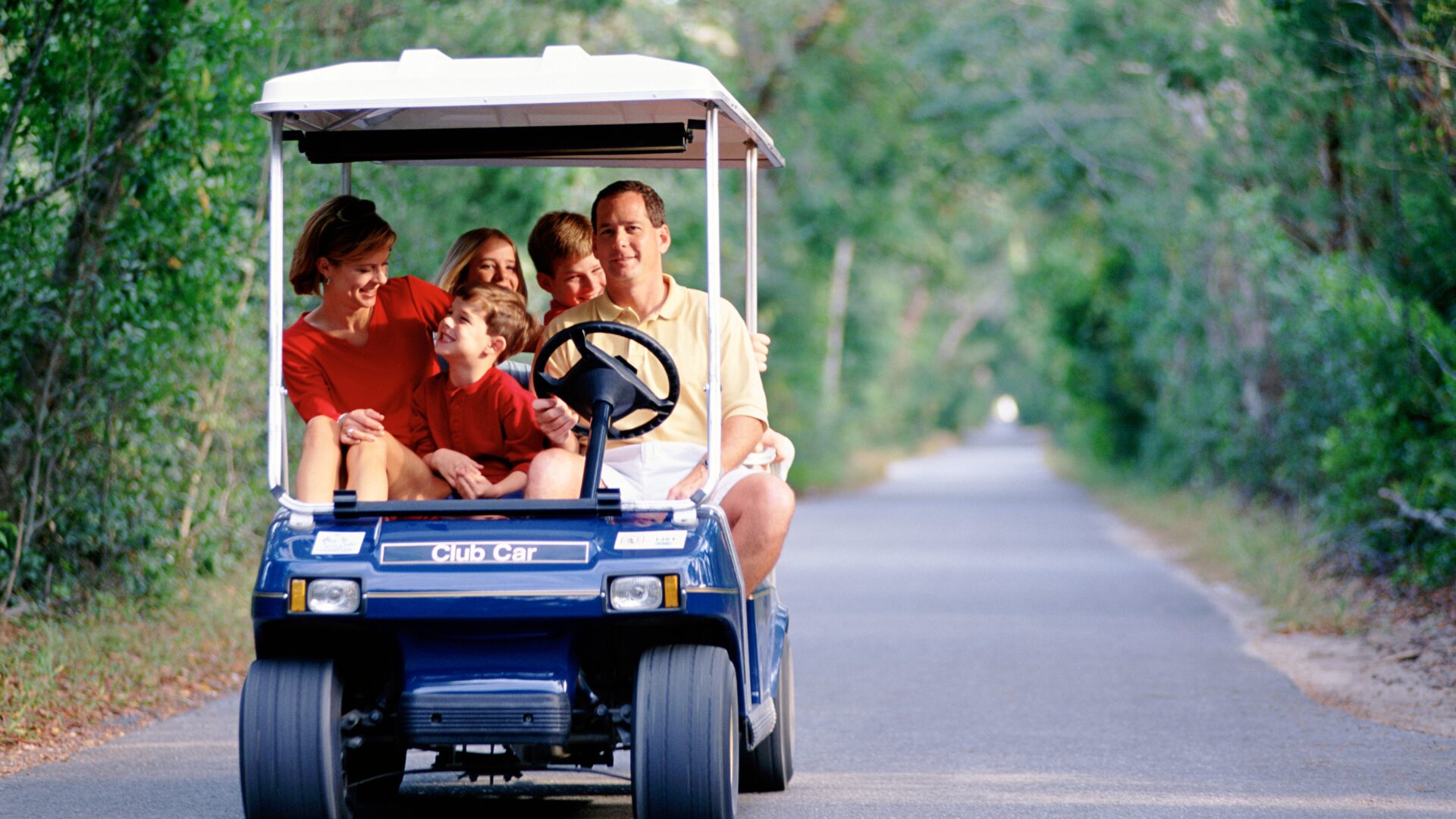 family on golf cart